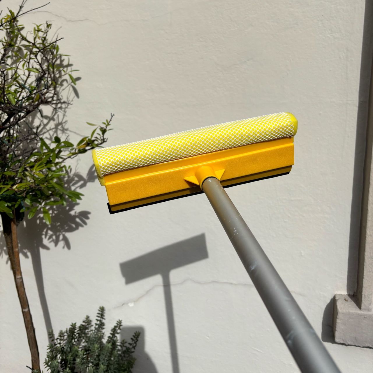 squeegee attachment on the easy clean telescopic hose brush outside a house