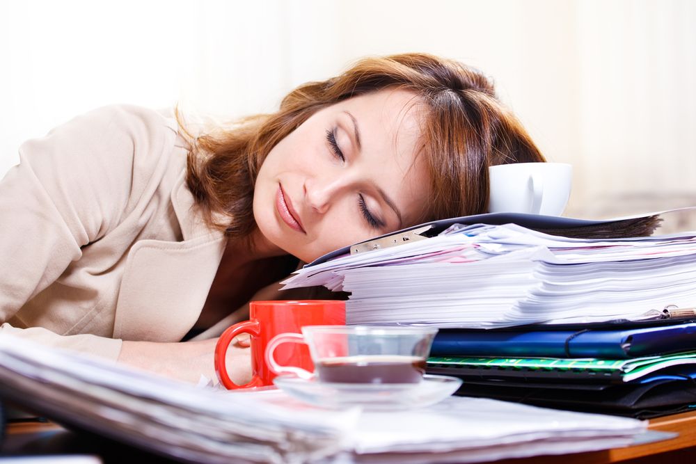 A woman sleeps on her desk