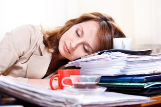 A woman sleeps on her desk