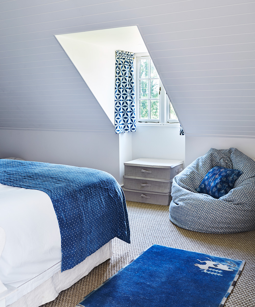 Small bedroom ideas for kids in a blue and white color scheme with sloped ceiling and beanbag.