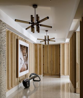 An entryway with a small bench, an artwork and ceiling light