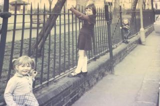 Natasha and her siblings play on a fence in the street