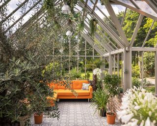 sitting area in a large greenhouse filled with climbing plants