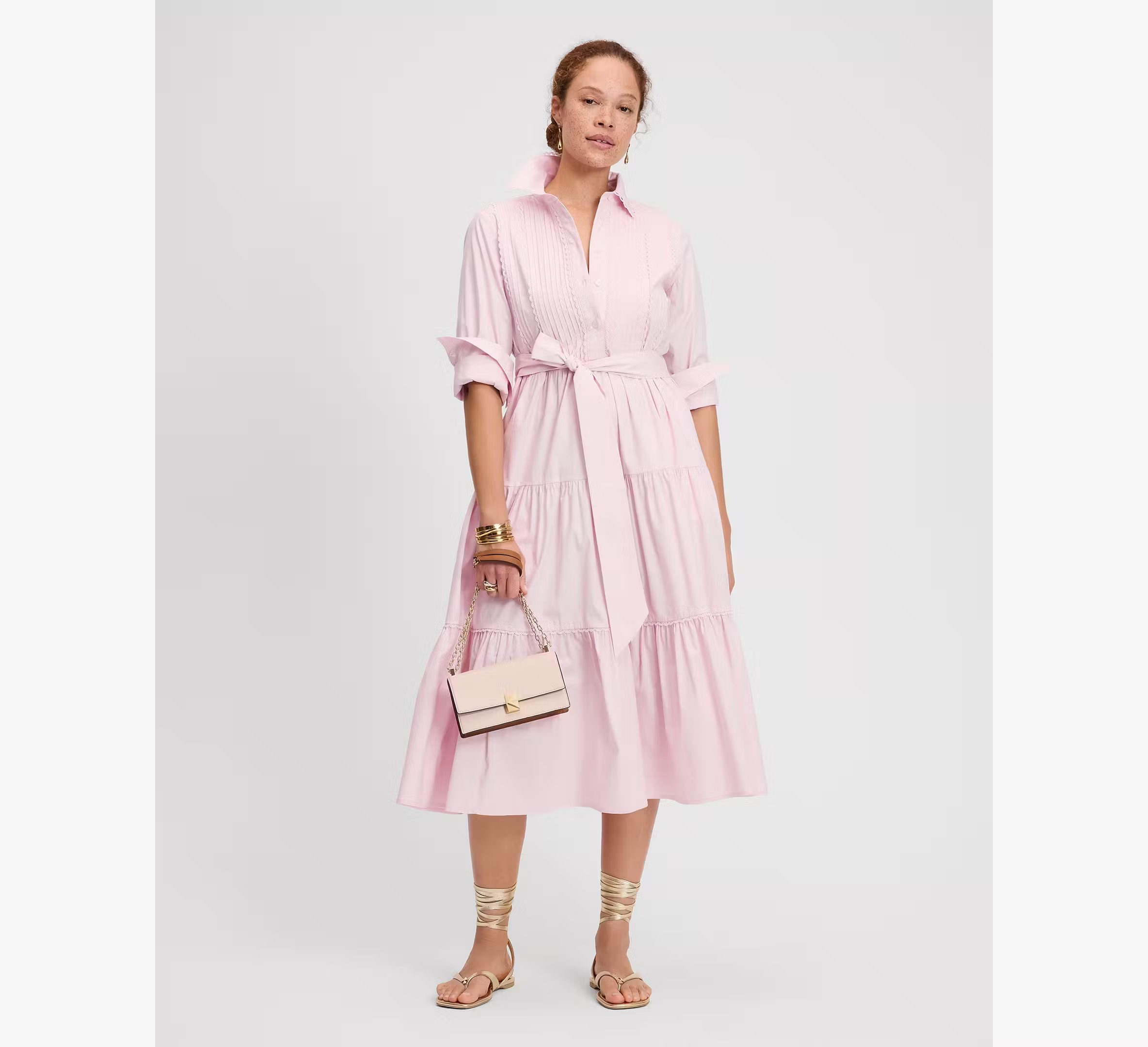 A model wearing a pale pink shirt dress