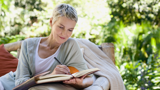 Woman writing in notepad