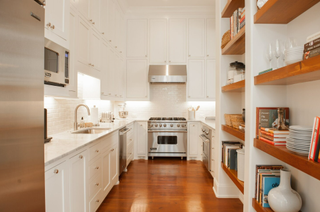 White kitchen with wood floor and stainless steel appliances
