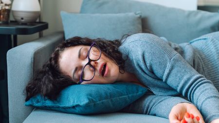 A woman naps on the sofa during the middle of the day