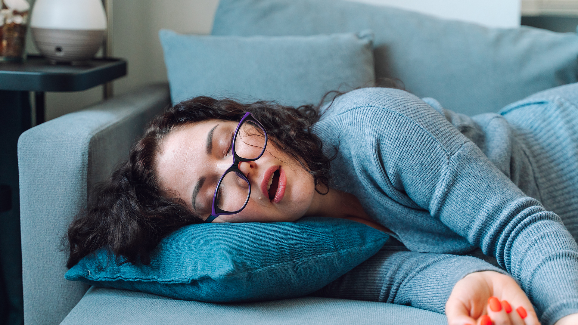 A woman naps on the sofa during the middle of the day