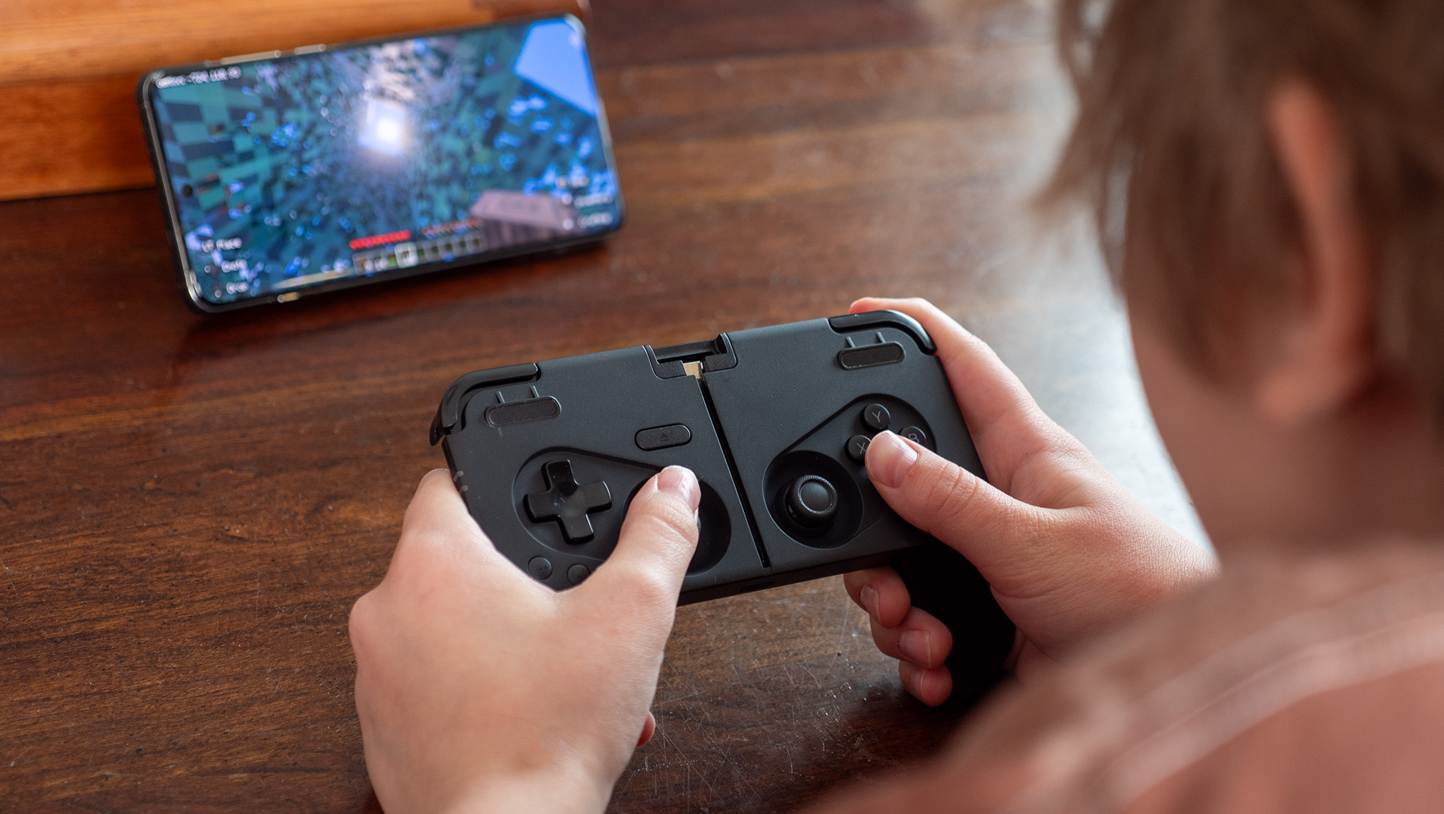 Playing Minecraft on a OnePlus 13 with a Thinborne case and a black Ohsnap MCON controller