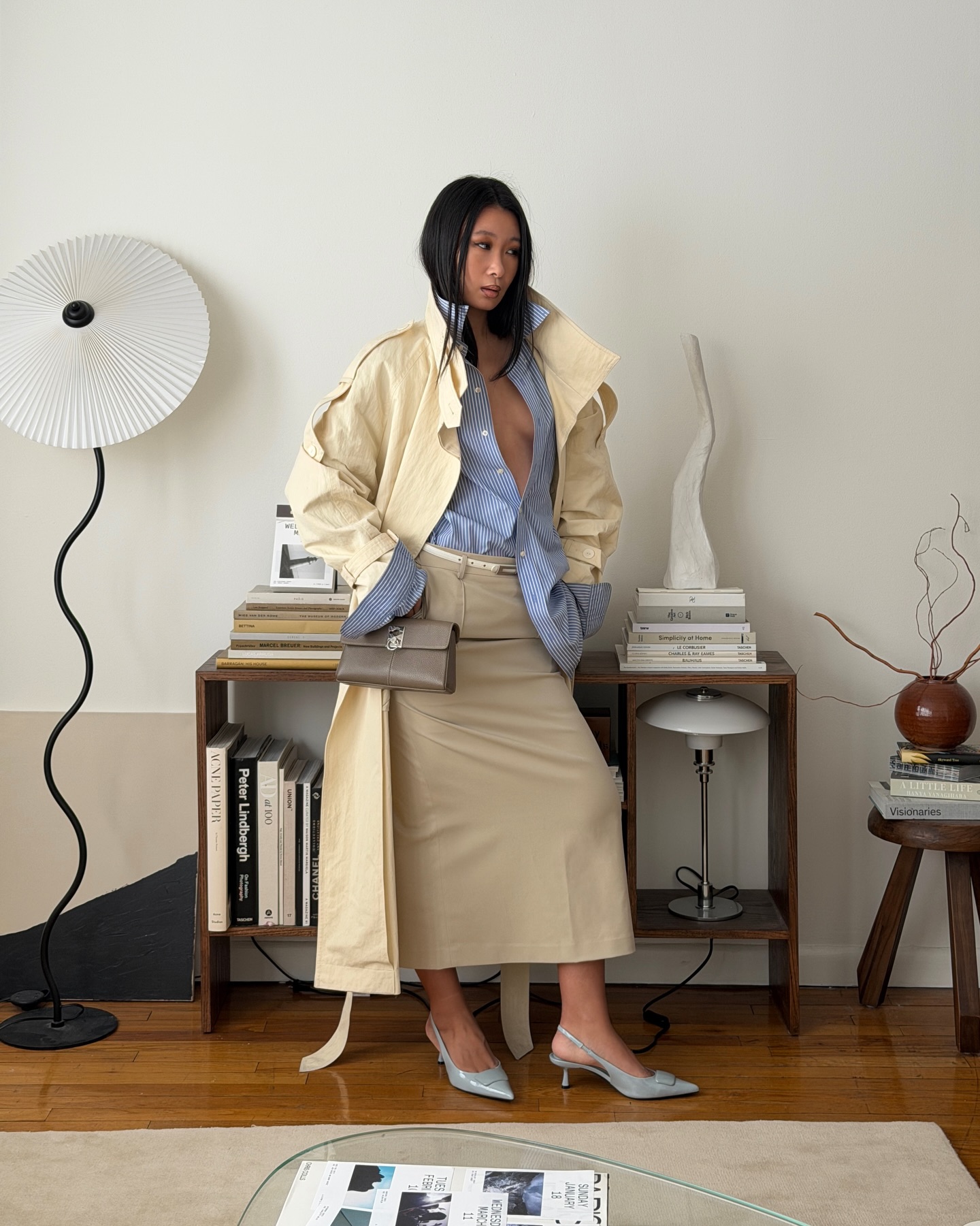 caroline lin wears a trench coat, blue shirt, pencil skirt and slingbacks