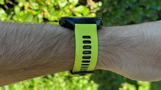 A side view of the Garmin Forerunner 965 and its Amp Yellow silicone watch band.