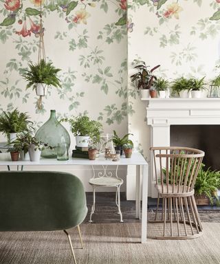 Spring mantel ideas with green plants in white pots on white mantelpiece with green and white nature-inspired wallpaper