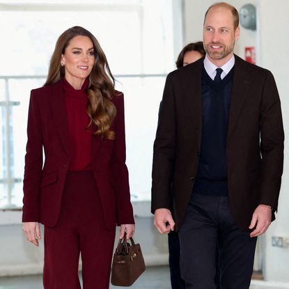 Princess kate wearing a maroon suit walking next to Prince William