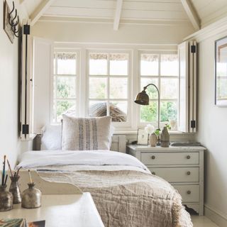 tiny guest room ideas, white bedroom with single bed, desk, chest of drawers, shutters, mirror