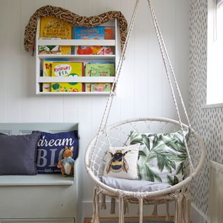 white boys child bedroom with hanging macrame swing wall hung book shelf and bench