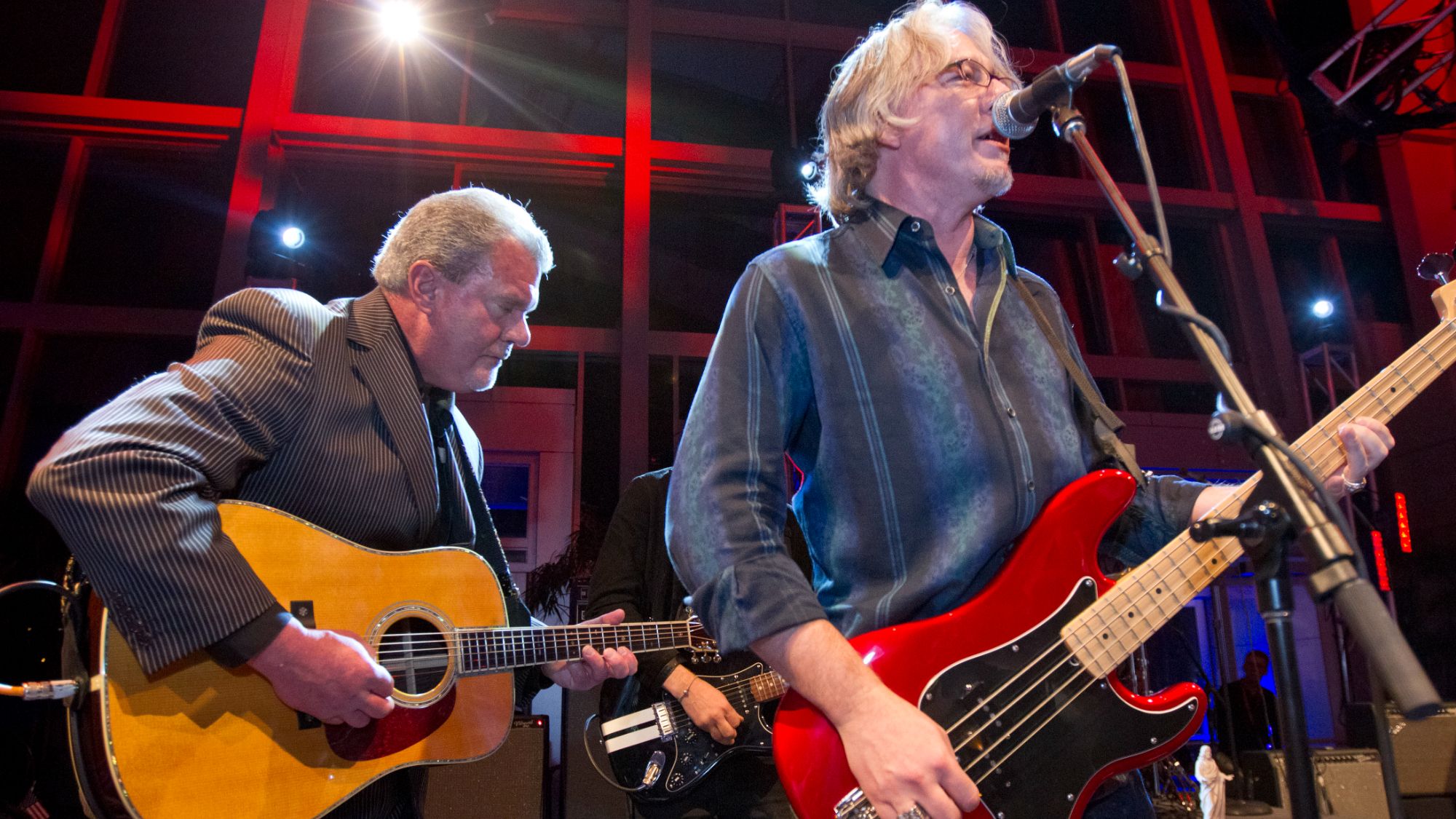 Colts owner Jim Irsay plays rhythm guitar as bass player for REM, Mike Mills, takes the lead during a private Super Bowl party hosted by Irsay, owner of the Indianapolis Colts at the Indiana State Museum and Historic Sites on Thursday, Feb. 2, 2012