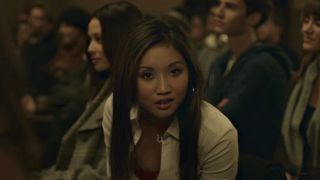 Brenda Song leaning over to speak with Andrew Garfield in The Social Network