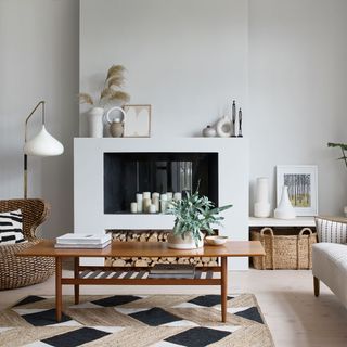 White living room with geometric rug and black fireplace