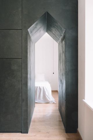 black pointed arch in a passageway into a bedroom