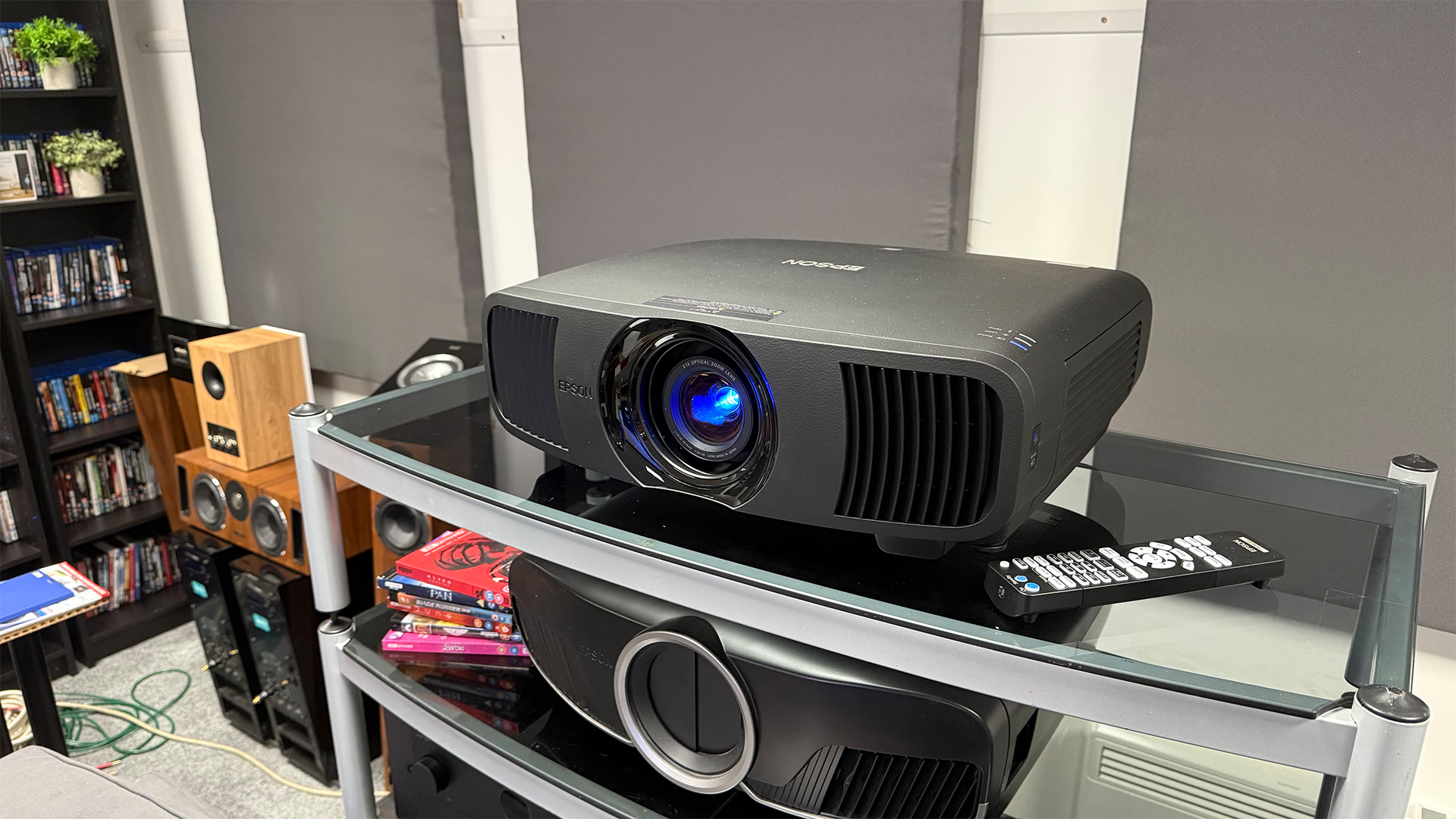 Epson EH-LS9000 home cinema projector on glass AV rack with other hi-fi and AV gear in shot