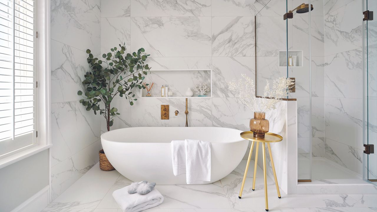 White bathroom with marble wall panels and white bath