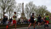 Participants run near the Eiffel Tower during the Paris Marathon 2024