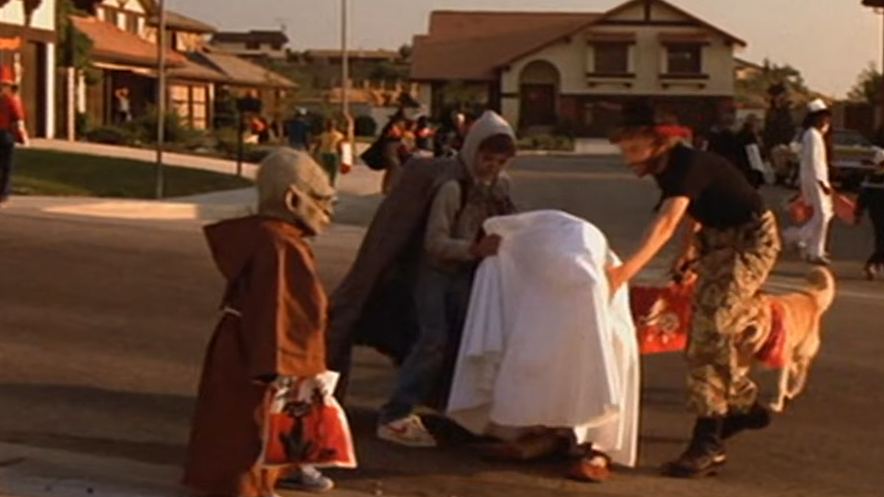 A person dressed in a Yoda costume walking by ET dressed as a ghost on Halloween