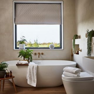 bathroom with wooden floor and glass window with blind and bathtub and towel