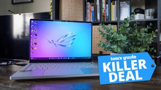 Asus ROG Zephyrus G14 on table next to plant with Tom's Guide Killer Deal badge