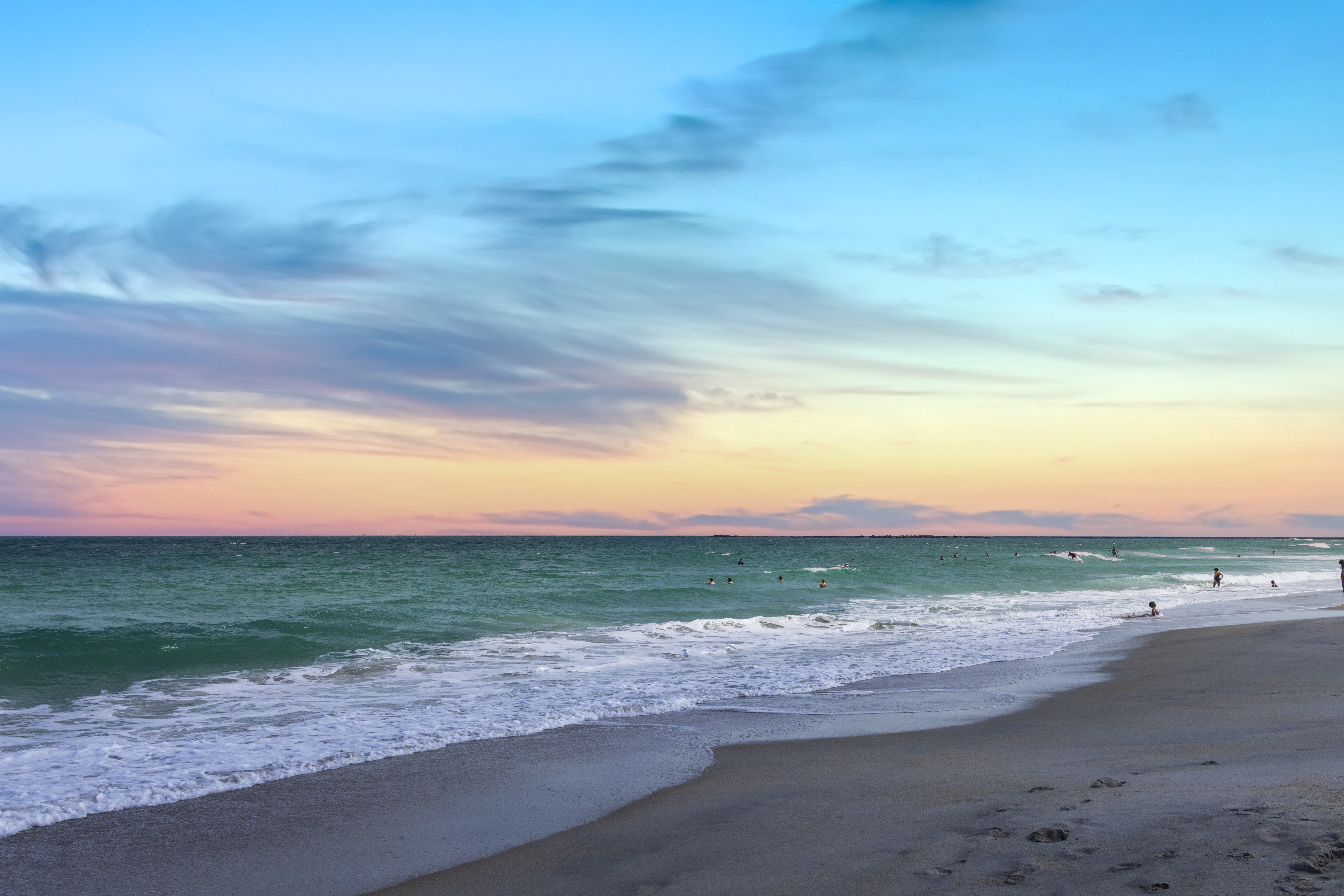 People in the water at sunset in Wrightsville Beach
