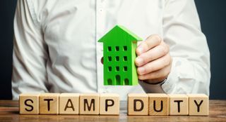 Blocks of wood saying Stamp Duty with a green toy house above