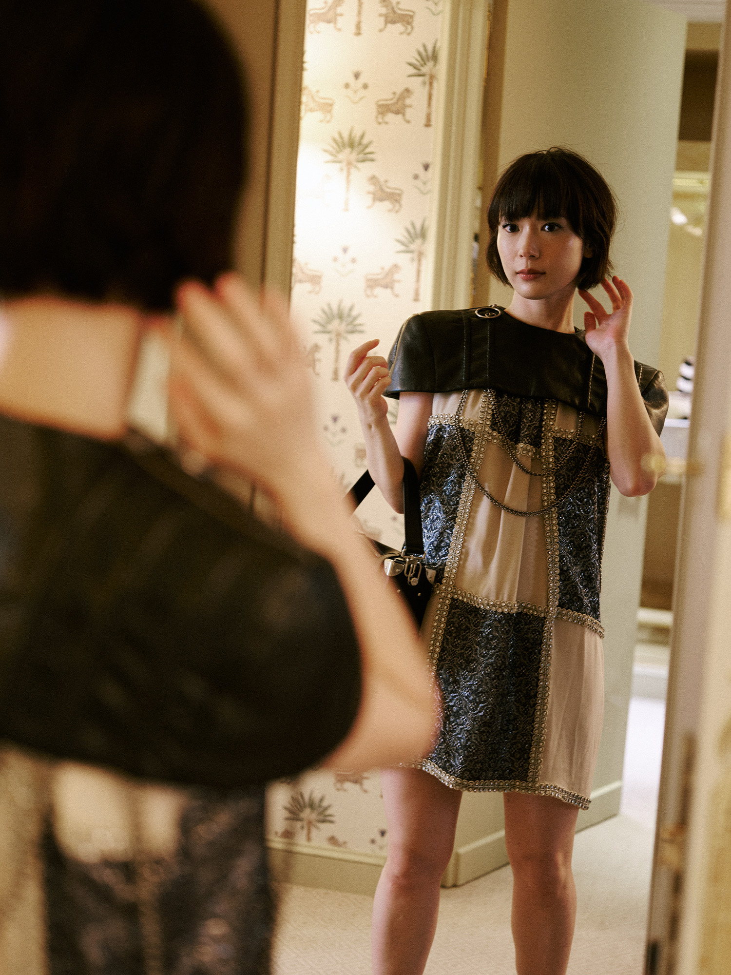 Moeka Hoshi Paris Fashion Week photo diary for the Louis Vuitton Spring 2026 show. Moeka is looking at herself in the mirror in her final look before heading to the Louis Vuitton show.