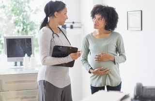 Woman and doctor discussing fibroids when pregnant