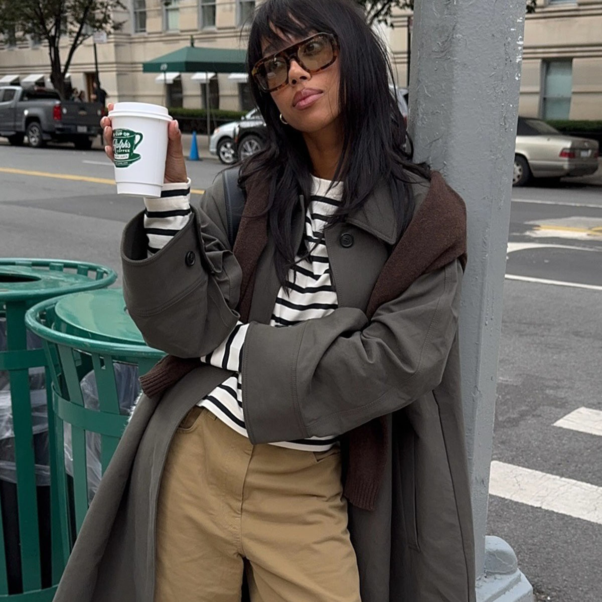 Woman in trench coat, striped tee, and khaki pants