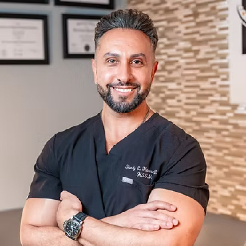 Man smiling at viewers with arms crossed