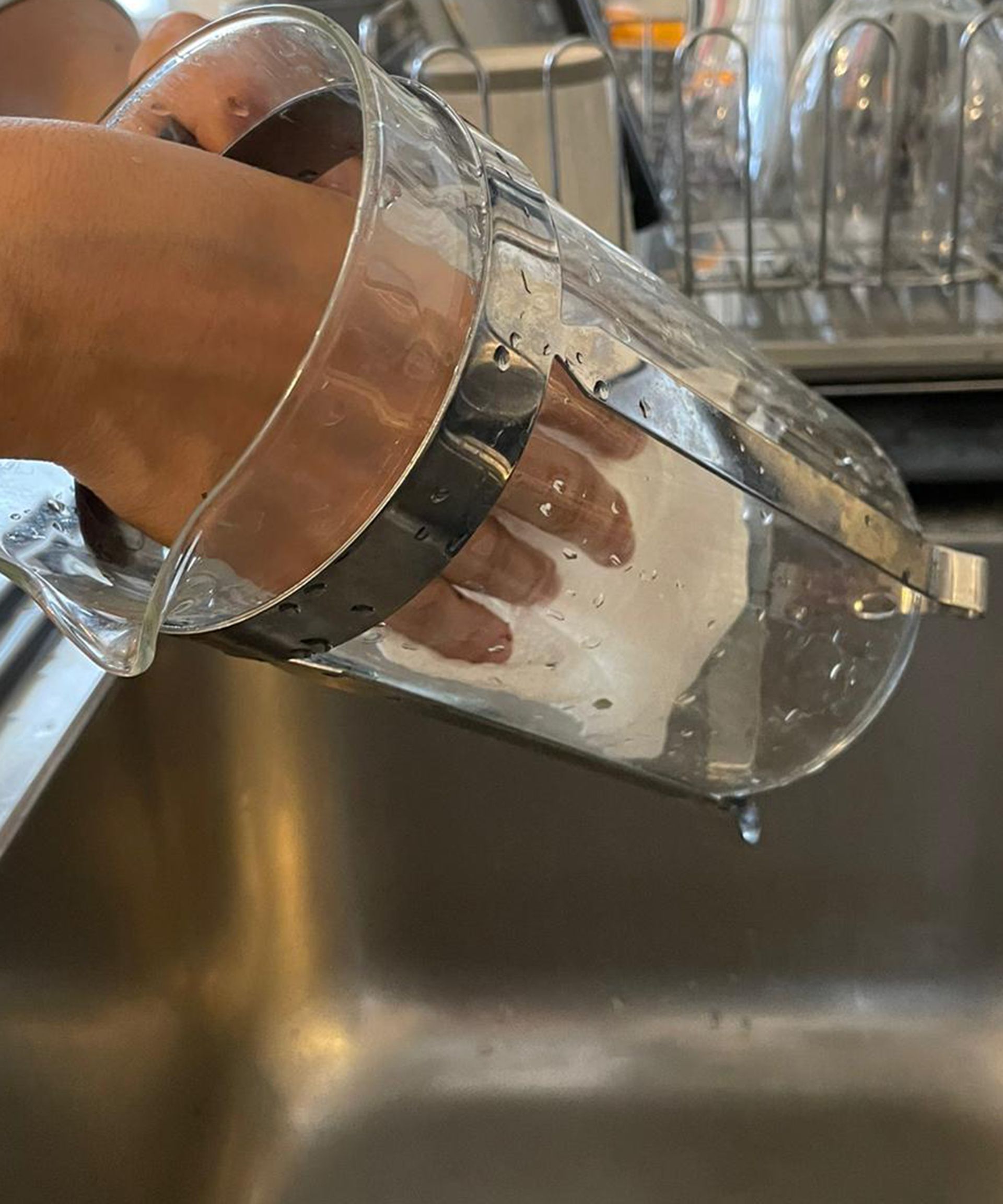 Tampilan dekat Christina Chrysostomou sedang menyeka French Press dengan handuk kertas