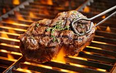 A steak on a lit barbecue grill