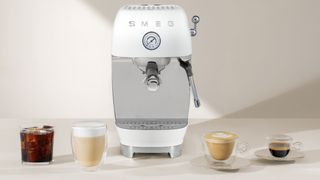 Smeg ECF03 coffee machine on counter with coffee drinks