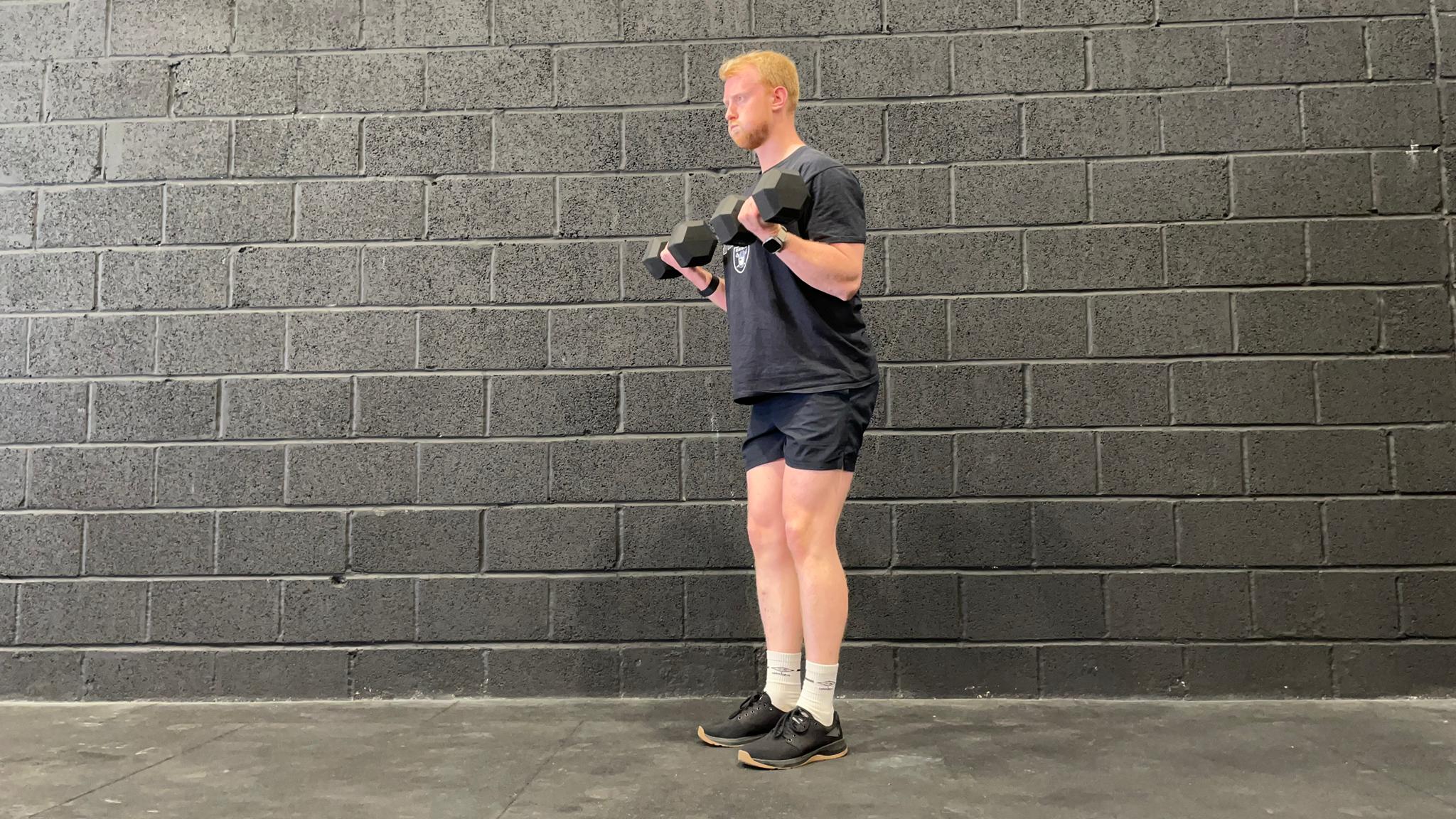 TechRadar fitness writer Harry Bullmore demonstrating a dumbbell curl