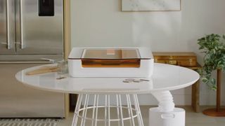 Glowforge Aura; a small white laser machine on a desk