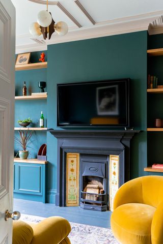 a tv over a fireplace in a blue room