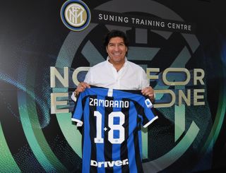 Ivan Zamorano holds an Inter shirt with his name and old number at the club's training base in 2019.