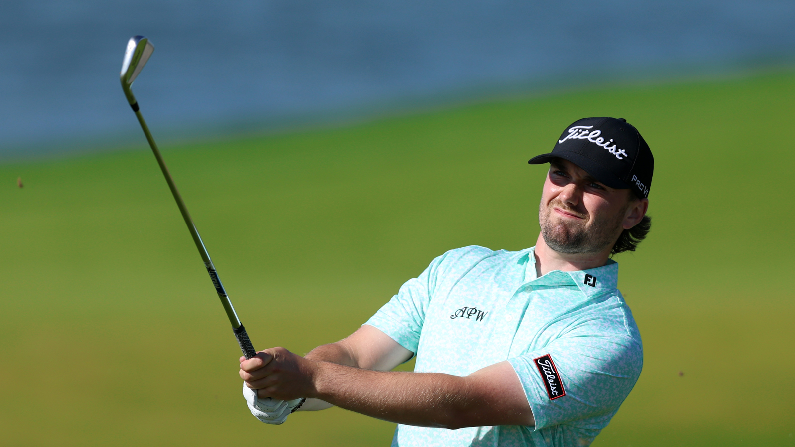 Cameron Adam hits an iron shot and watches it