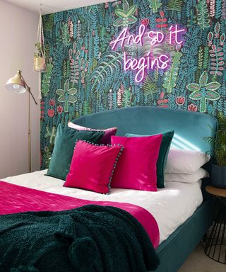 bedroom with colorful leafy wallpaper, headboard and pink cushions