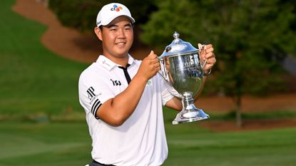 Joohyung Kim poses with the trophy after his win in the 2022 Wyndham Championship