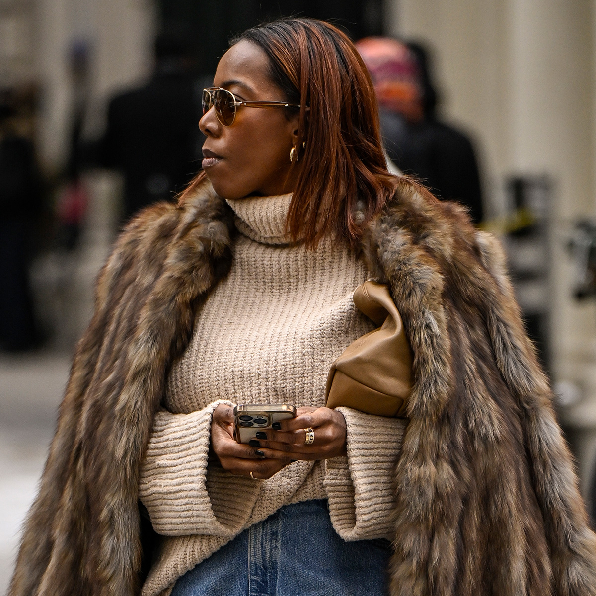 NEW YORK, NEW YORK - FEBRUARY 11: Tiffany Reid is seen wearing a brown fur coat, cream sweater, jean skirt, brown heels and tan bag outside the Kallmeyer show during NYFW F/W 2025 on February 11, 2025 in New York City. 