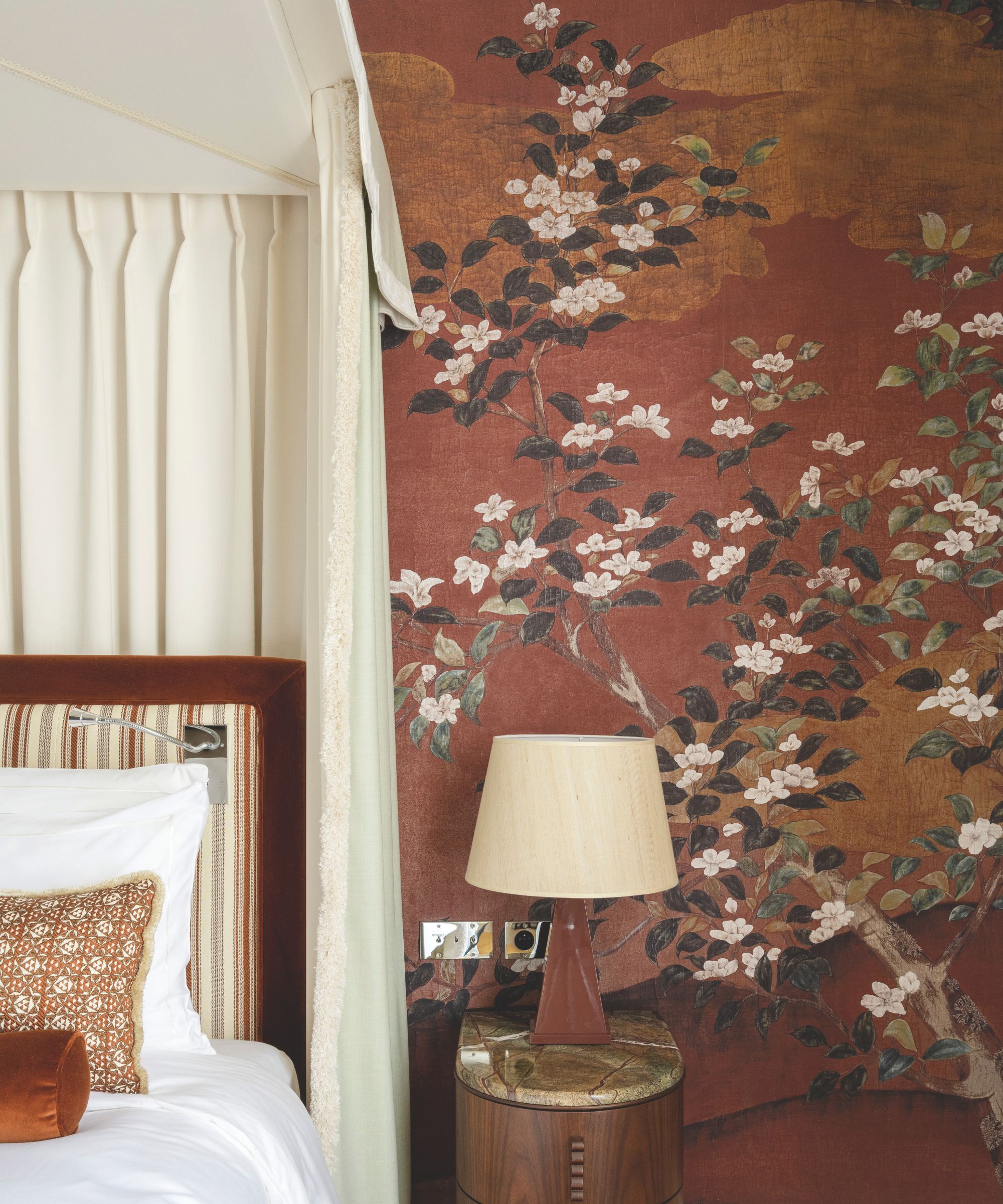 Red Japanese wallcovering behind a four poster bed