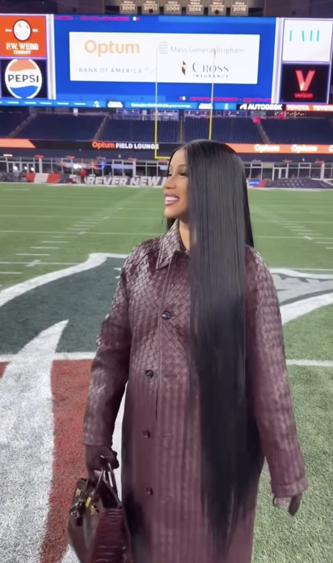 Cardi B attended a New England Patriots football game while wearing a burgundy Bottega Veneta game day outfit