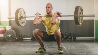 Man performs barbell front squat