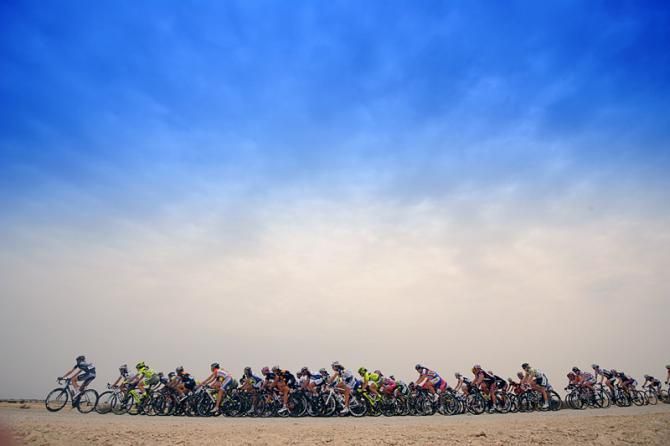 The peloton rolls through the stark Qatari landscape.
